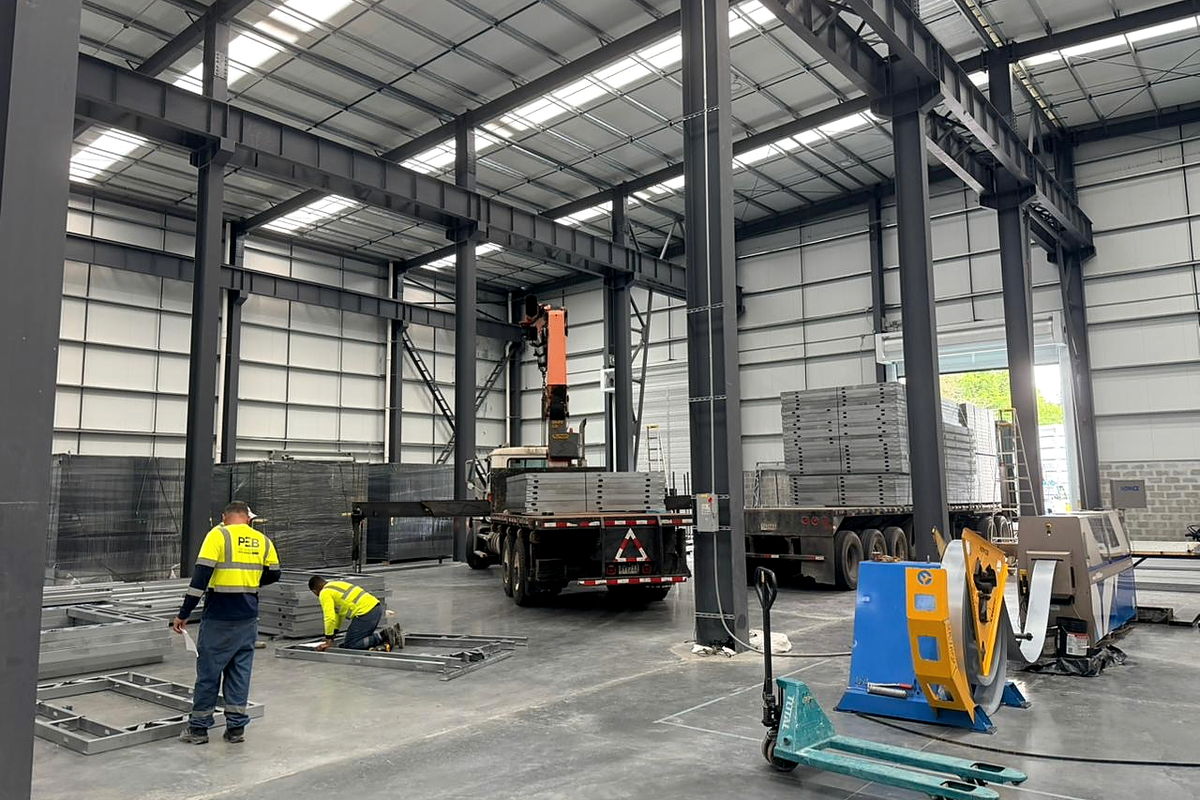 Nave de producción de la planta del grupo, operada por NewCon Steel® en el Centro Industrial PEB, Las Mañanitas: pórticos de acero, puente grúa y paneles de acero conformado en frío en el piso
